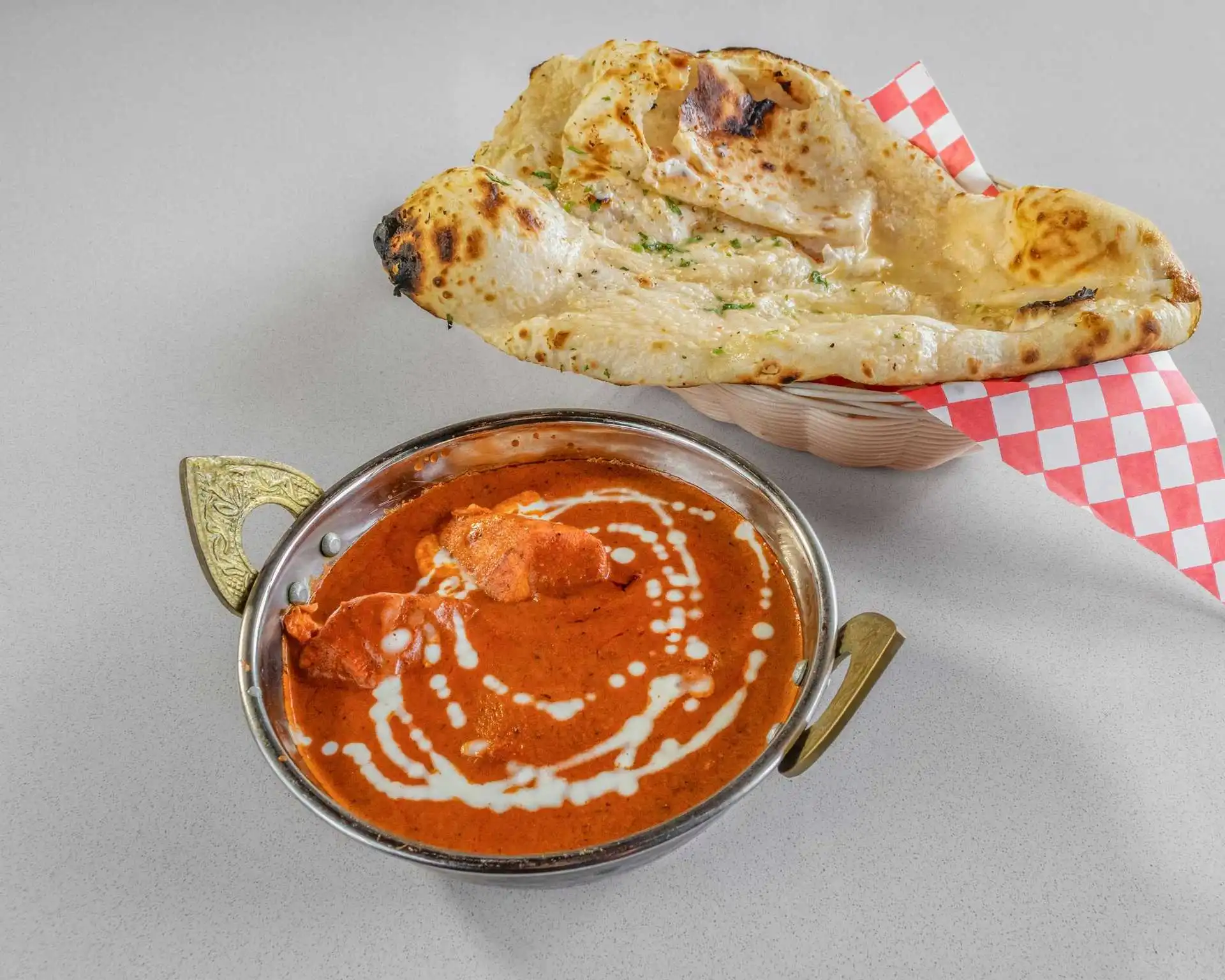 Creamy tomato curry served with fresh grilled flatbread at Dak Land Restaurant in Warman