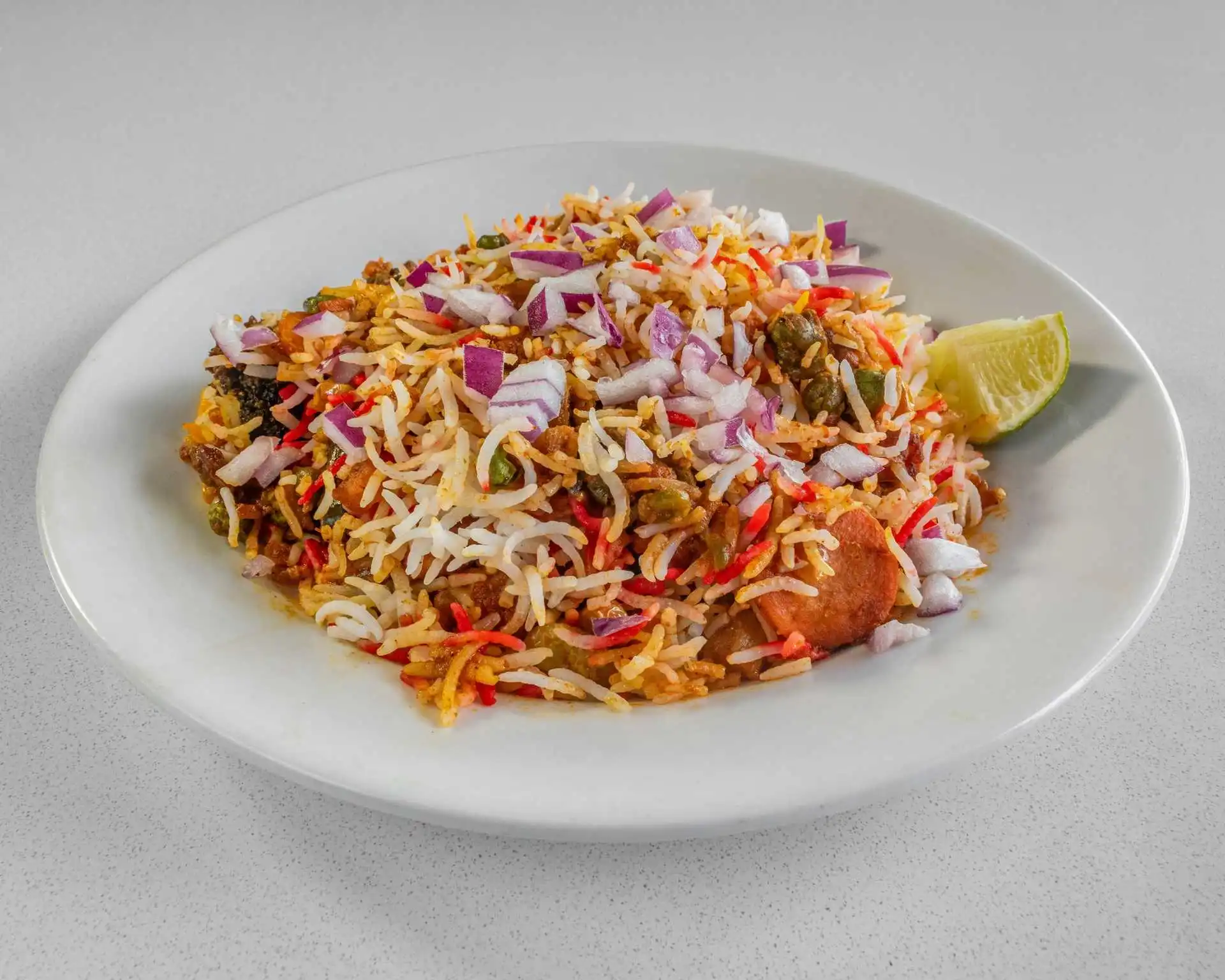 Fragrant spiced rice plate with fresh onions at Dak Land Restaurant in Warman, Saskatchewan