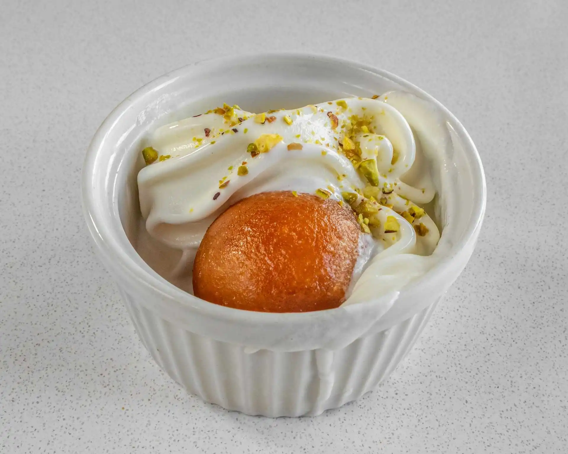 Warm sweet dessert topped with cream and pistachio at Dak Land Restaurant in Warman, SK